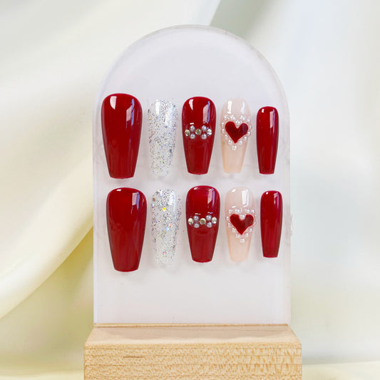Set of red and decorative false nails on a display stand with a white background
